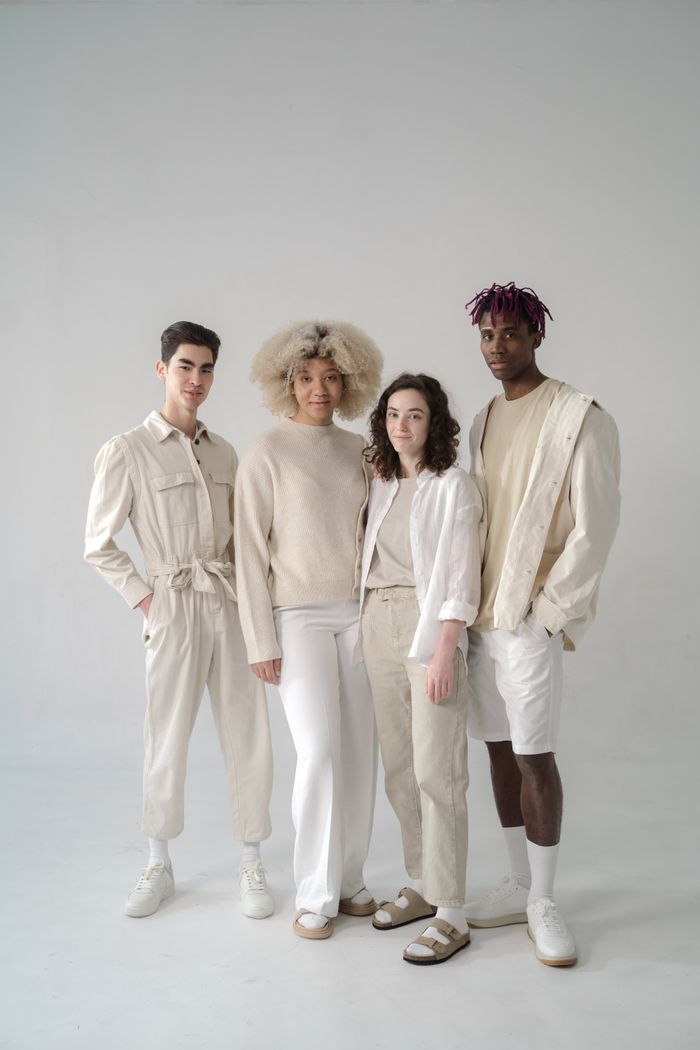 our-story A diverse group of models posing stylishly in a studio shoot wearing neutral tones.